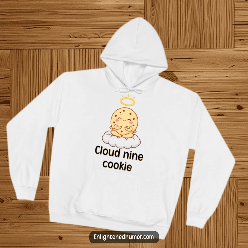 Funny Cookie Meditation Hoodie showing an exuberant cookie meditating on a cloud with a halo, offering sweet, humorous comfort.